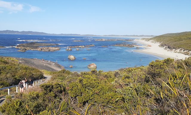 Turquoise water and granite boulders at Greens Pool, with a beach and coastal vegetation.
